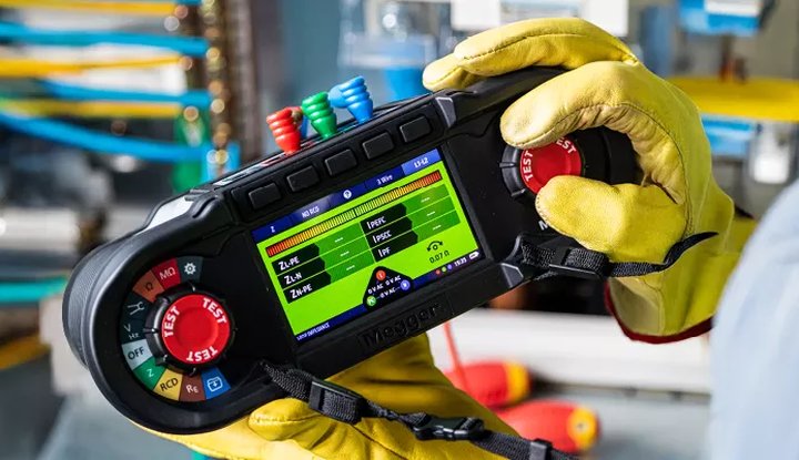 Gloved hands holding a Megger multifunction tester